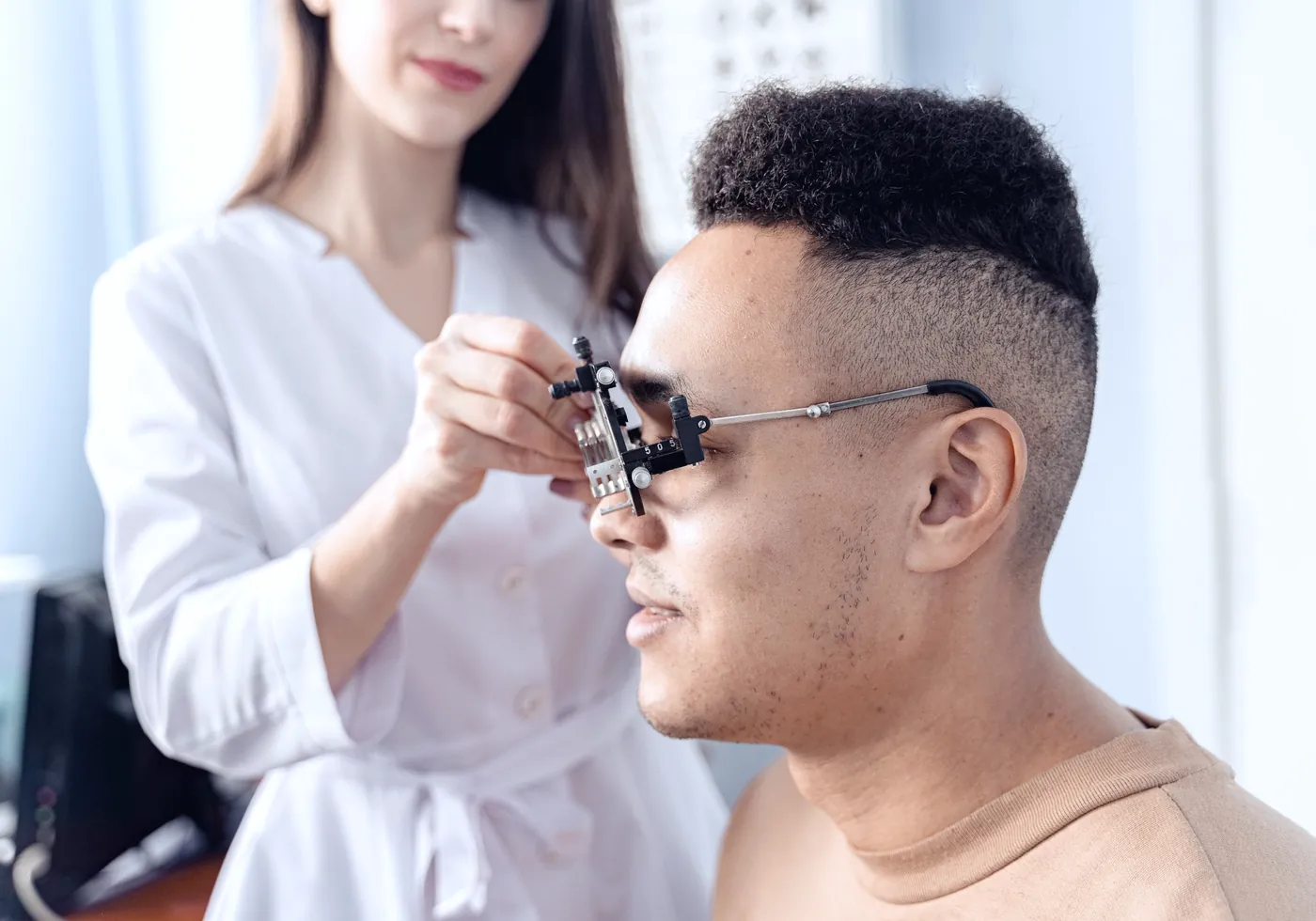 Optometrista colocando una montura de prueba a un paciente